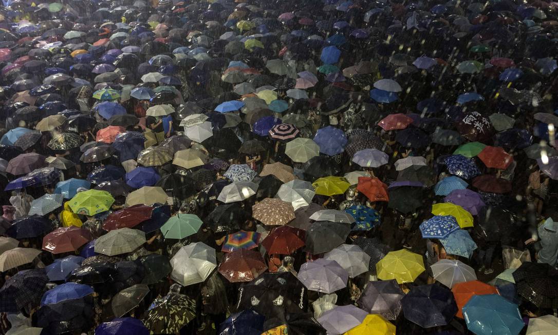28 de outubro. Manifestantes da Revolução do Guarda-chuva, que o usaram para se proteger também do spray de pimenta, celebram um mês desde que foram às ruas no distrito financeiro de Hong Kong para reivindicar voto universal e reforma política. Foto: Anthony Wallace / AFP