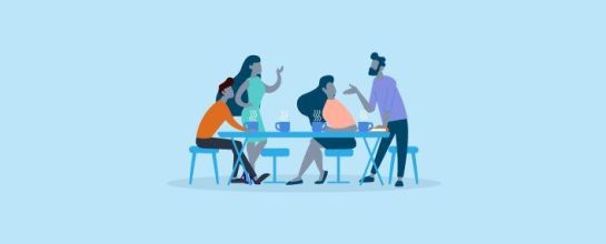 Pessoas no ambiente de trabalho ao redor de uma mesa discutindo ideias
