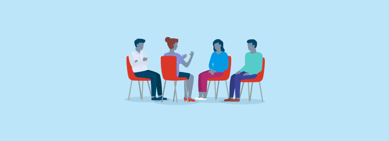 Quatro pessoas sentadas ao redor de uma mesa trocando ideias
